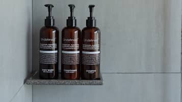 Three bottles of Undefined body wash, conditioner, and shampoo on a shelf.