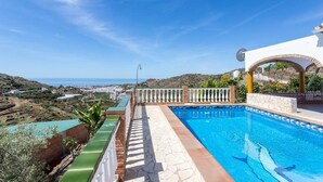A pool with a clear view of the sea and a white building with arches. - Cortijo Tomé Solset (Torrox)
