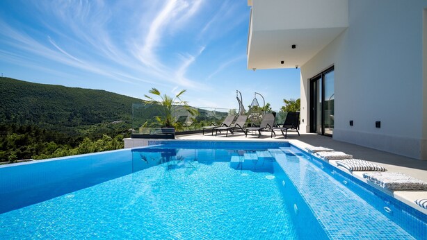 A modern outdoor swimming pool with clear blue water, surrounded by lounge chairs and a white building with large windows. - Villa Top Hill,heated pool,Jacuzzi,Sauna,5 en-suite bedrooms,Media room (Tugare)