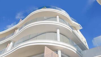 A modern building with curved balconies and large windows.