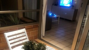 Une table ronde avec des chaises, une plante en pot et une télécommande.
