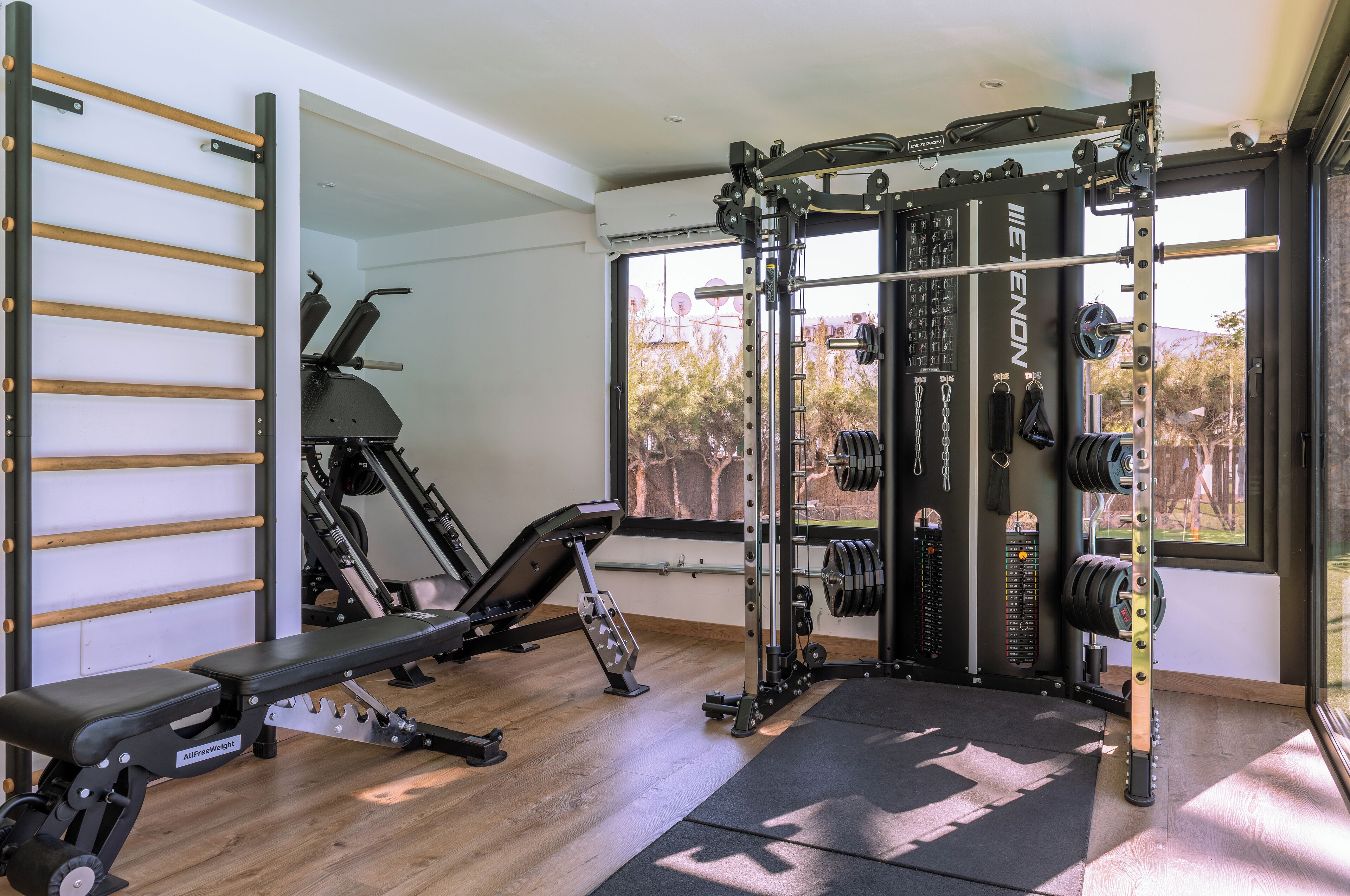 A gym with a pull-up bar, a bench, and a squat rack.