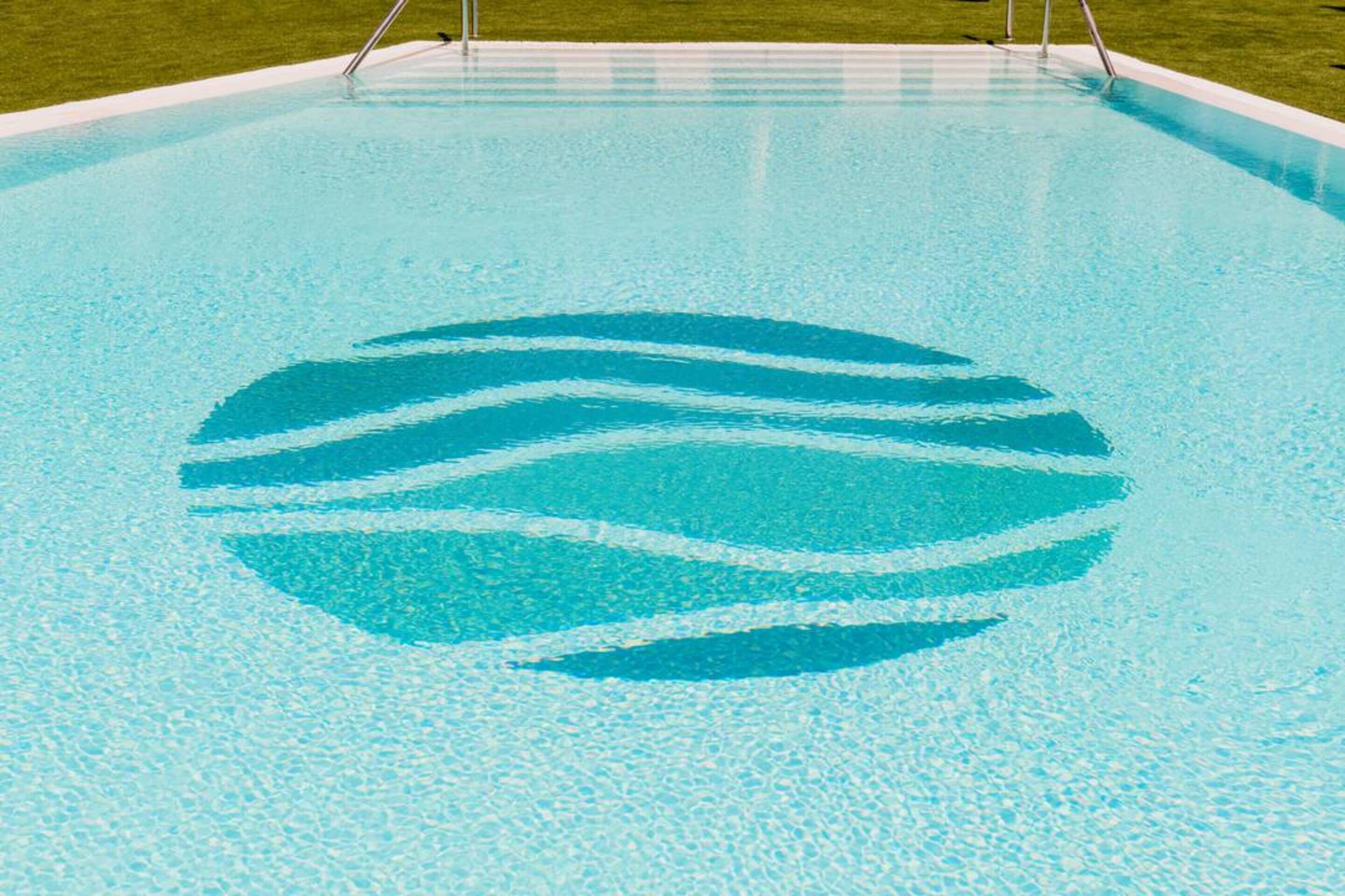 Una piscina con un diseño de olas azules y blancas en el piso.