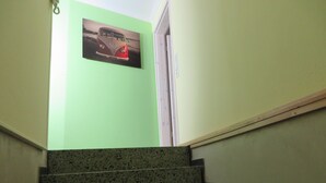 A staircase with a green wall and a picture of a car.