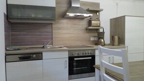 A modern kitchen with a stove, oven, sink, and a coffee maker on the countertop.