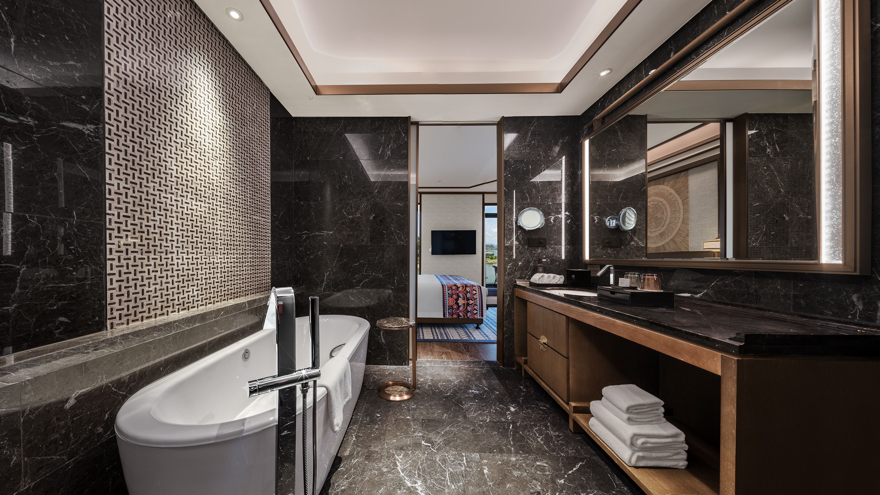 A modern bathroom with a bathtub, a large mirror, and a vanity with a sink.