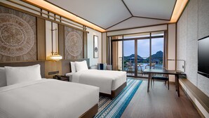 A hotel room with two beds, a desk, and a large window offering a view of the mountains. - Steigenberger Guilin (Guilin)