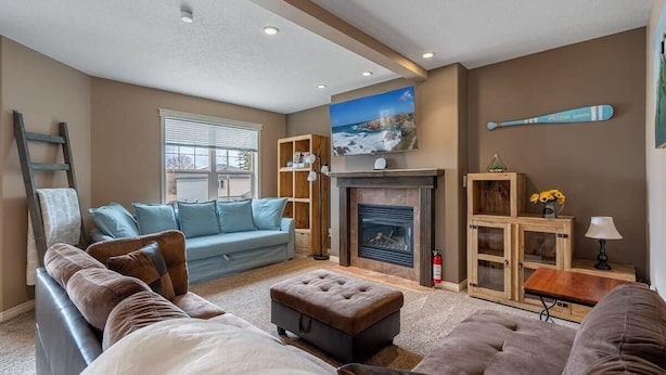 A living room with a fireplace, a sofa, a coffee table, and a television.