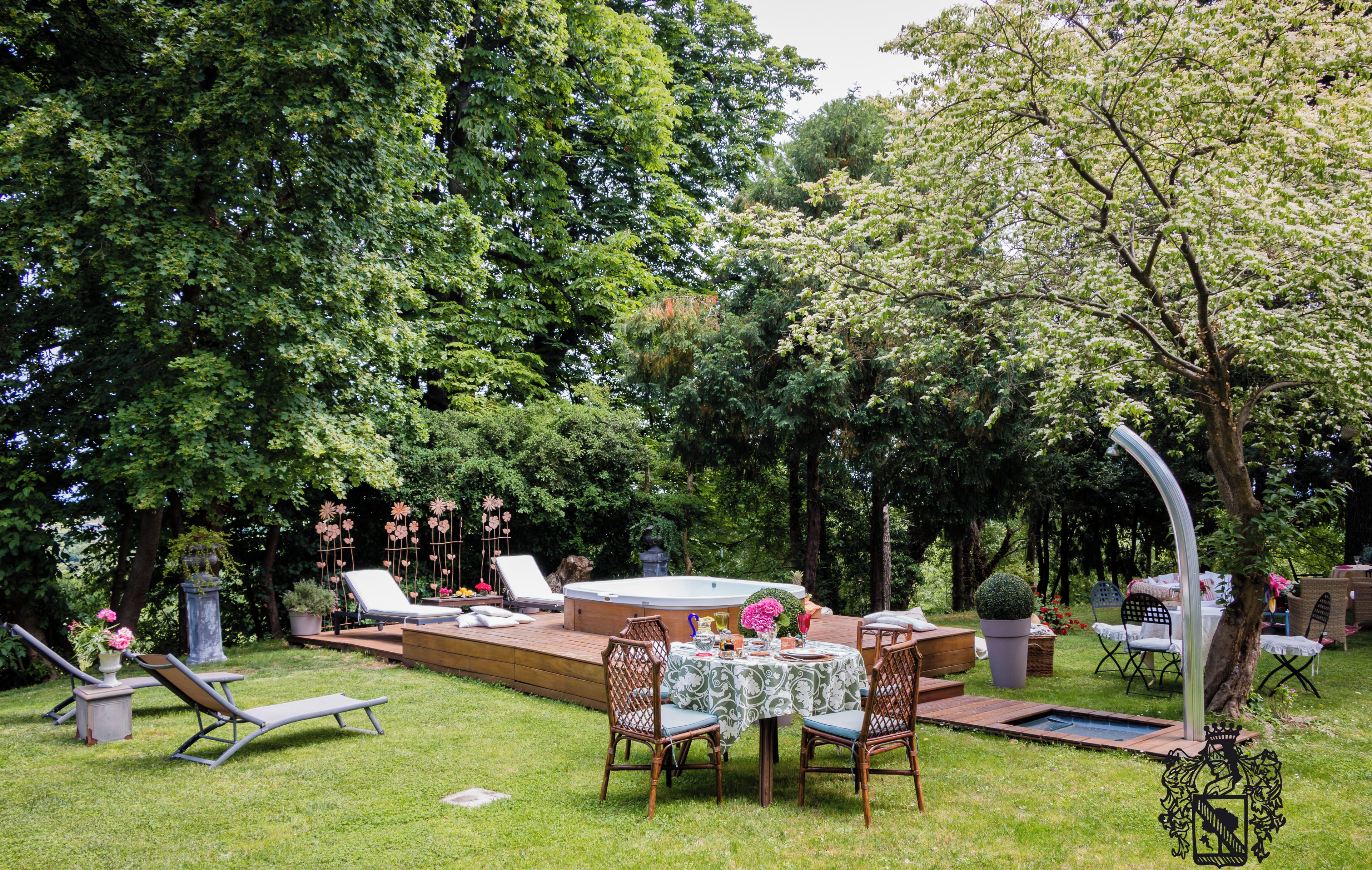 Un jardin avec un jacuzzi, des chaises longues, une table à manger et une terrasse.