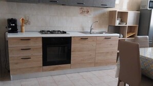 Een moderne keuken met een centraal eiland, inbouwoven en een spoelbak.