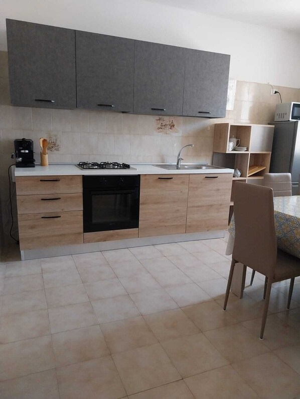 Een moderne keuken met een centraal eiland, inbouwoven en een spoelbak.