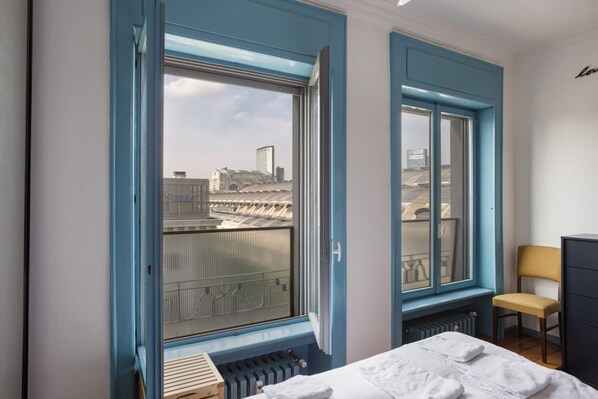 A bedroom with a large window, a radiator, a bed, and a chair. - The blue nest with a view - Palestrina (Milano)