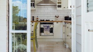 Cocina con armarios blancos, estufa y microondas.