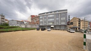 Ett hotell med en parkeringsplats och flera bilar.