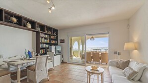 Un vaste espace de vie comprenant une table à manger, un canapé et une bibliothèque.