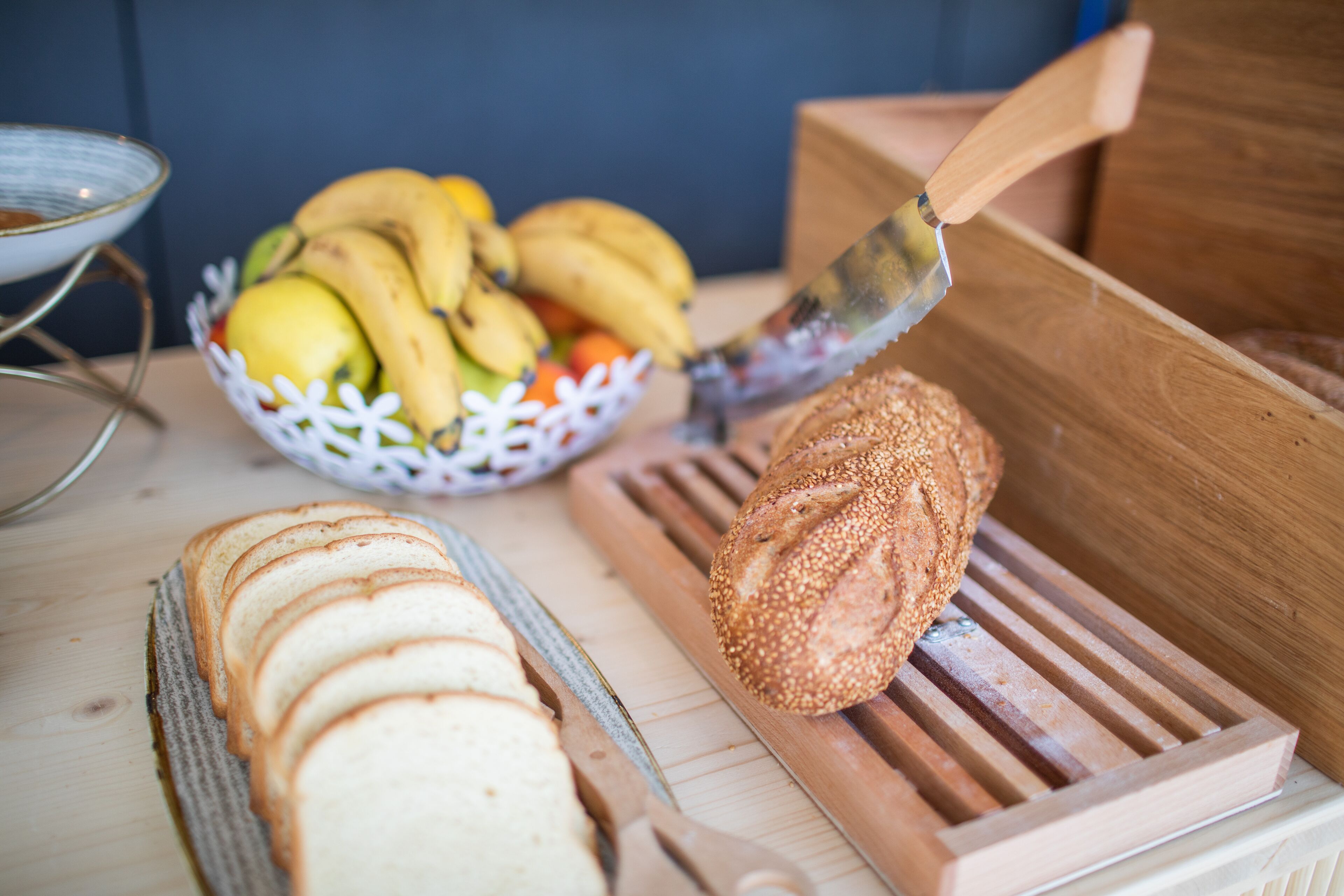A wooden cutting board with a loaf of bread and a knife.