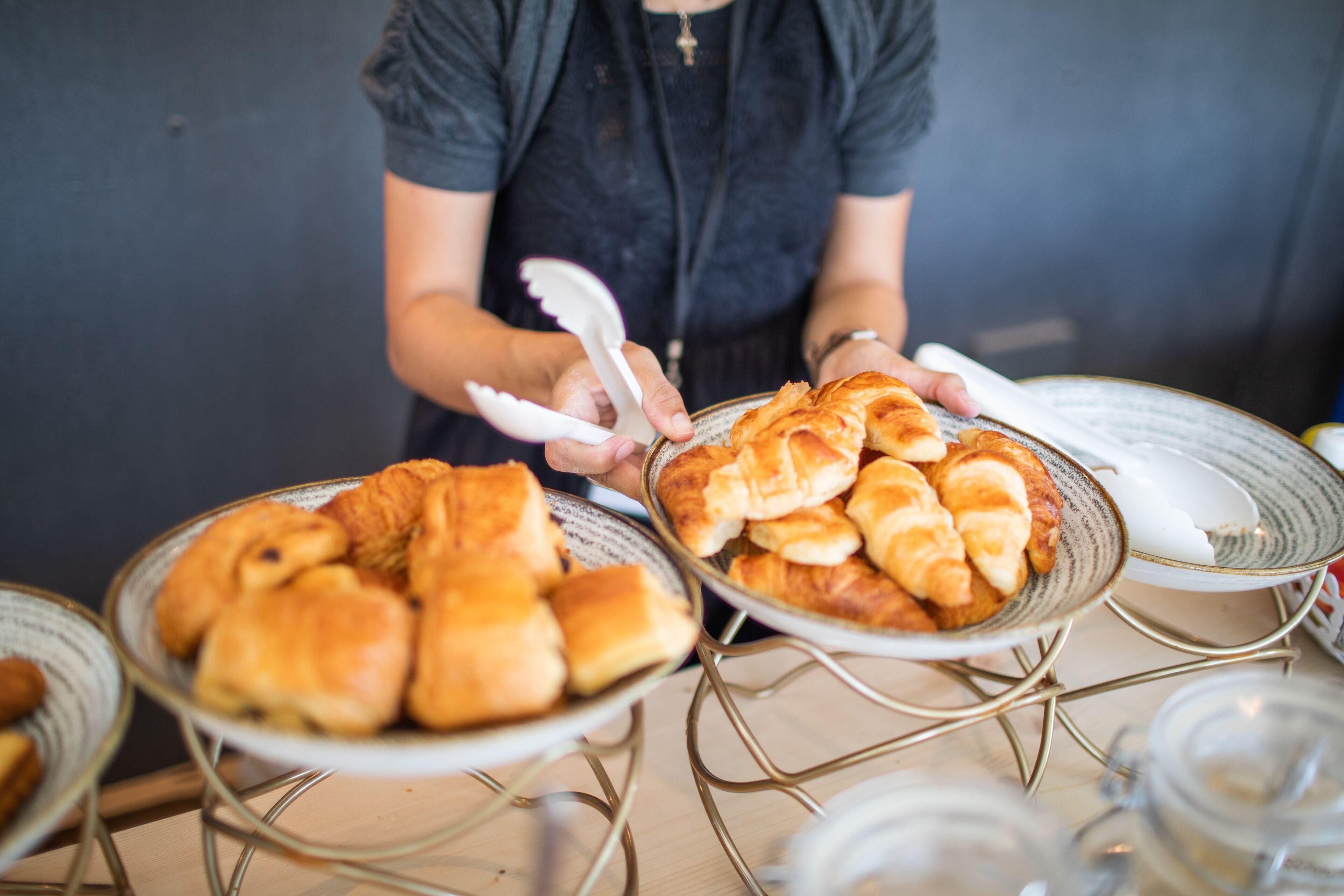 A person serving pastries from a tray.