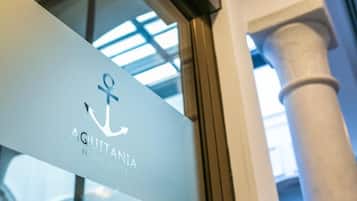 En skylt med texten ”AQUITANIA HOME SUITES” och en ankarsymbol.