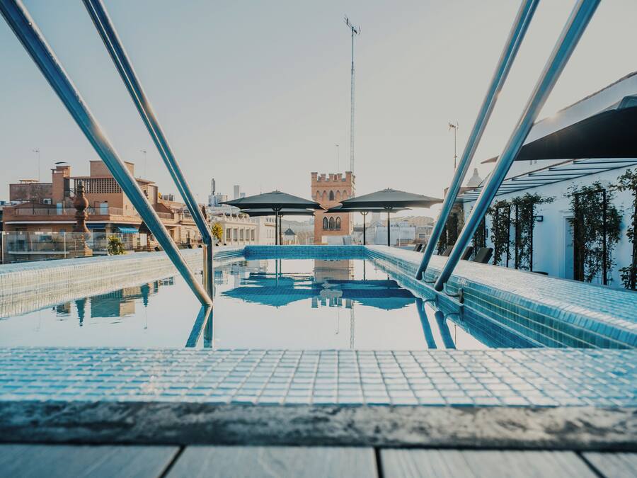 Piscina com vista clara dos edifícios ao redor e uma torre ao fundo.