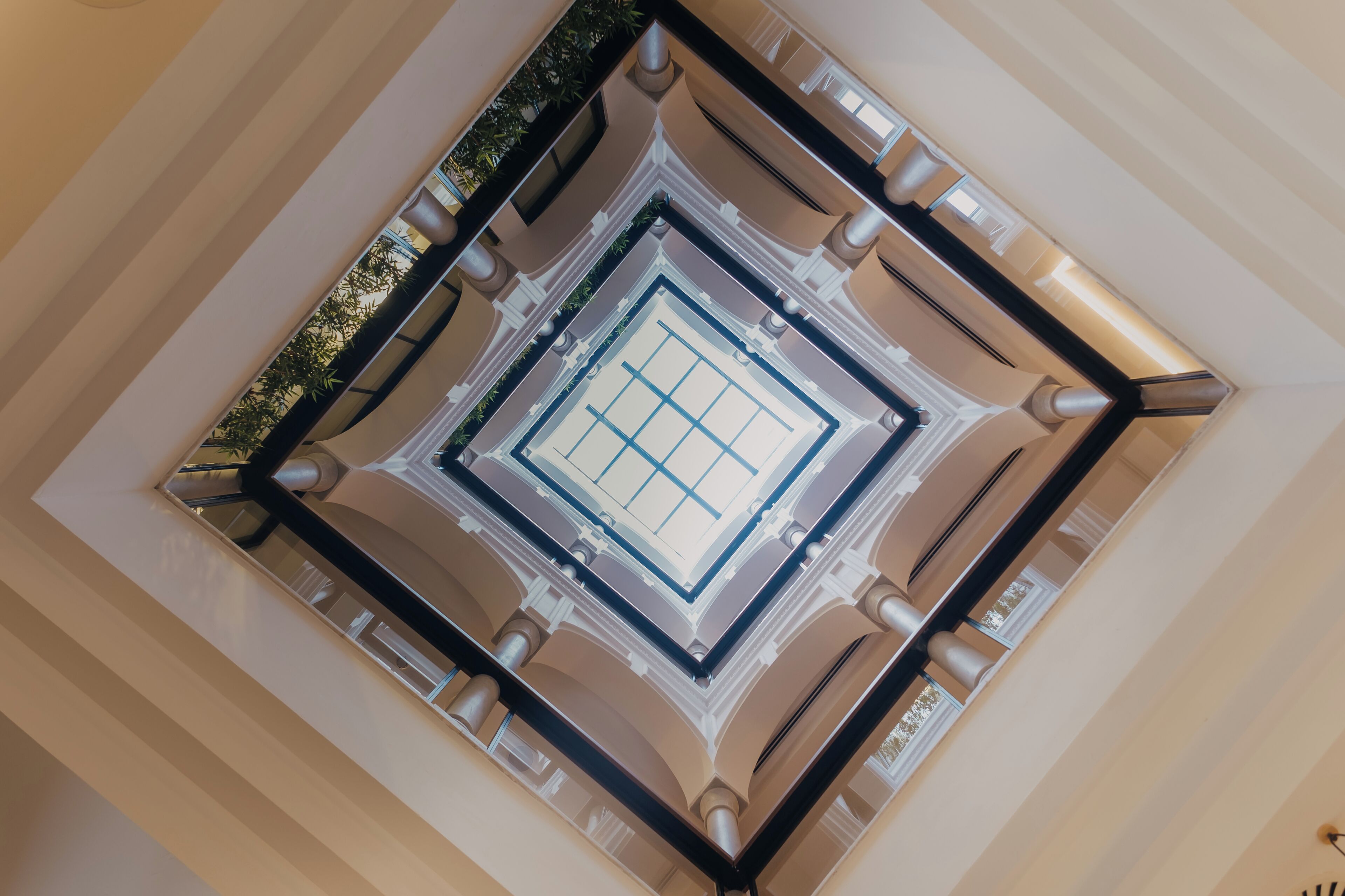 A high-ceiling atrium with a central skylight and symmetrical columns.