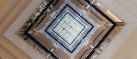 A high-ceiling atrium with a central skylight and symmetrical columns.