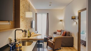 A modern kitchen with a brick wall, a dining area with a sofa, and a view of the outdoors.