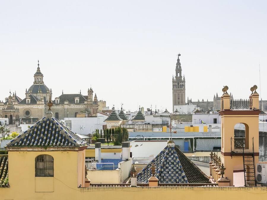 Un paisaje urbano con edificios históricos, incluyendo una torre destacada y una iglesia con cúpula.