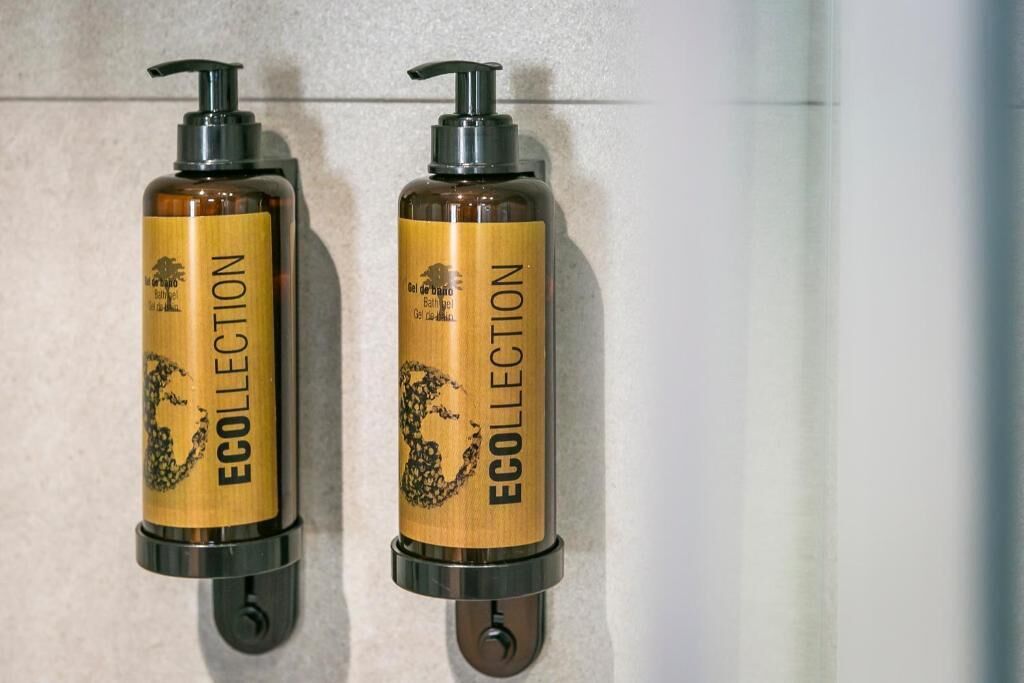 Two bottles of Ecollection bath gel mounted on a wall.
