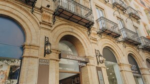 A historic building with a sign for 'AQUITANIA HOME SUITES'.