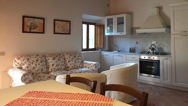 Una cocina pequeña con armarios blancos, una estufa a gas y una ventana.