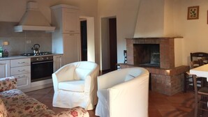 Una sala de estar acogedora con chimenea, un sofá y un comedor.