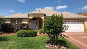 A single-story house with a beige exterior, a front door, and a garage.