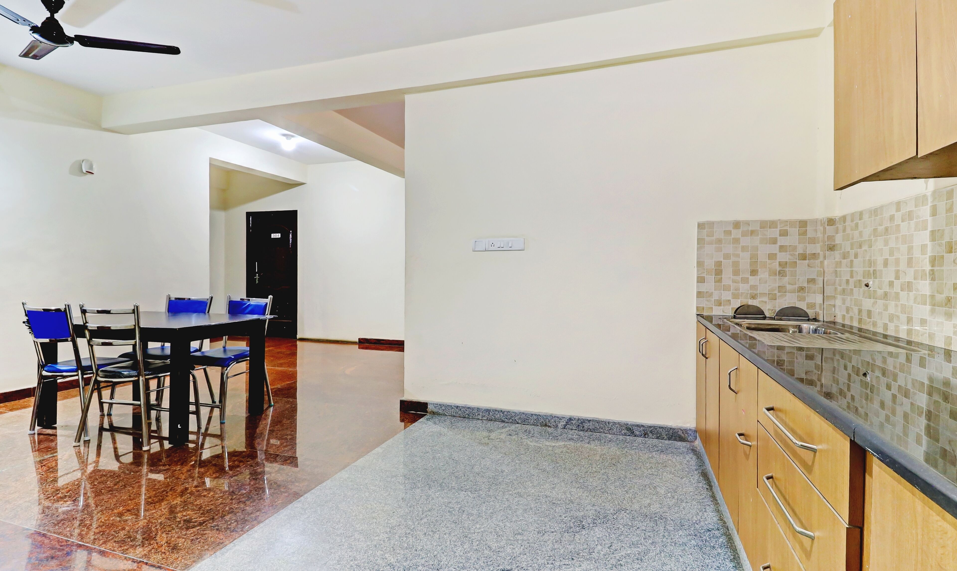 A modern kitchen with a tiled backsplash, wooden cabinets, and a countertop.