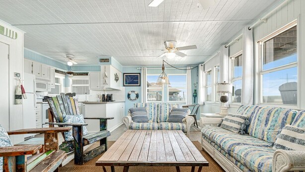 Un intérieur de style côtier, avec une table en bois, un canapé à rayures et des éléments de décoration sur le thème de la marine.