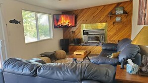 Ein Wohnzimmer mit Kamin, Fernseher und Sofa.