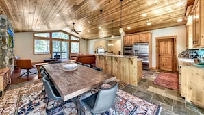 Une cuisine spacieuse avec des meubles en bois, un îlot central et une cheminée en pierre.