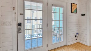 A room with two white doors, a light switch, a power outlet, and a framed map on the wall. - Renovated 3 BR, 2 BA w/Marsh Views & Short Walk to Beach (Garden City Beach)