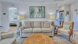 A living room with a sofa, armchairs, a coffee table, and a painting on the wall. - Renovated 3 BR, 2 BA w/Marsh Views & Short Walk to Beach (Garden City Beach)