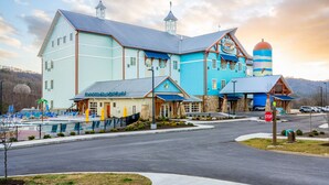 A large, multi-story building with a prominent tower and a silo, featuring a restaurant and a pool area. - The Lodge at Camp Margaritaville (Pigeon Forge)