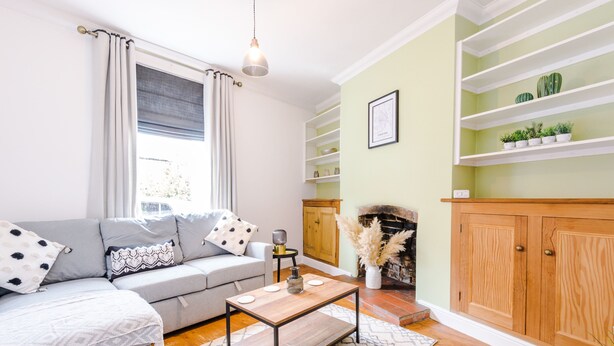 A living room with a grey sofa, a wooden coffee table, and a fireplace.