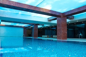 Una piscina techada, sillones reclinables de piscina