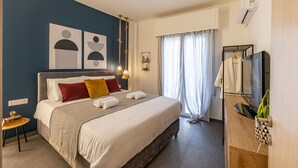 A hotel room with a large bed, a TV, a small table with a book, and a window with curtains. - Ports Crossroad E (Πειραιάς)
