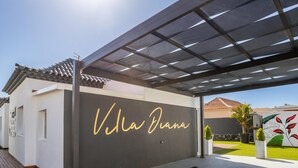 A modern villa with a large sign reading "Villa Diana" on the facade.