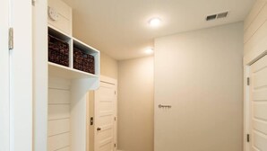 A hallway with a wooden floor, white walls, and a door with a keyhole. - Three Seas at the B, Walk to Tiki Bar and Beach (Carolina Beach)