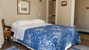 A bedroom with a bed, a chair, a wardrobe, and a bathroom visible through an open door. - Langridge Lodge Studio Residence by RedAwning (Alpine)