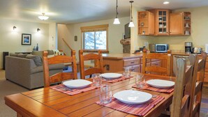 A dining area with a wooden table set for four, surrounded by wooden chairs. - Elk Lodge: Spacious Cabin Near Trails & Ski Access (Winthrop)