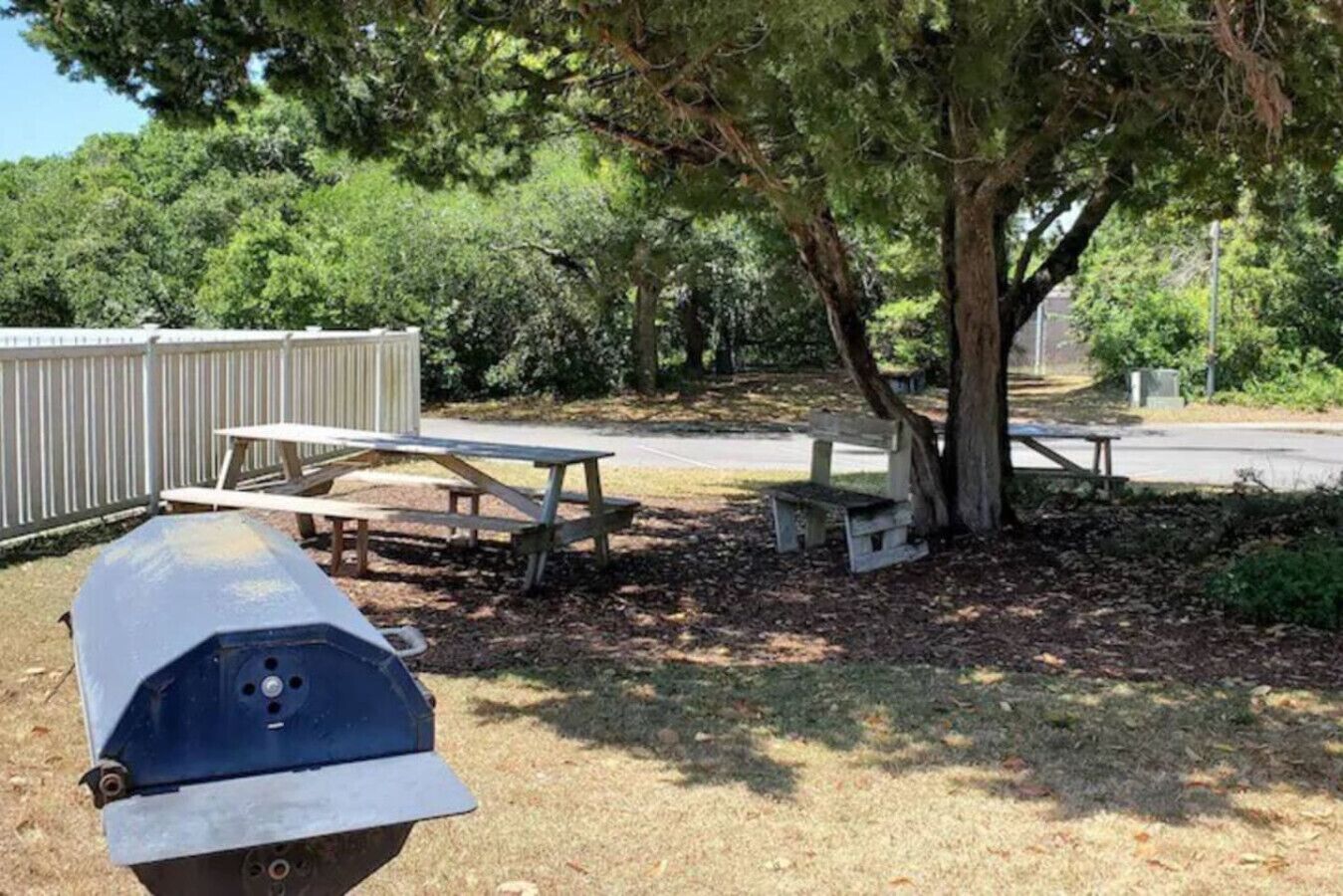 A picnic area with benches and a grill.