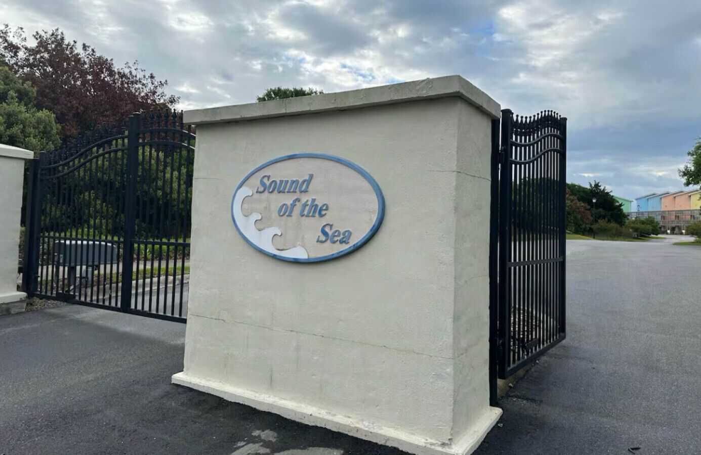 Ein Schild mit dem Schriftzug „Sound of the Sea“ auf einem Betonblock, umgeben von einem schwarzen Metallzaun.