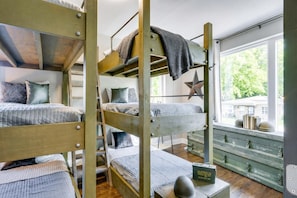 Quarto com beliche, decoração com tema de estrela e janela com vista para o verde.