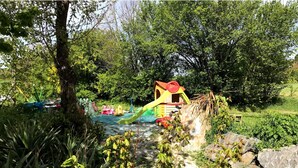A playground with slides and a playhouse, surrounded by trees and greenery. - Gîte & Bed and Breakfast capacity 14 people with swimming pool, labeled 4 keys. (MAUVAISIN)